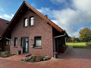 a red brick house with a brick driveway at Ferienhaus Weidblick in Westerstede