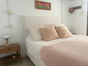 a bedroom with a bed with white sheets and pillows at Casa taller in Tigre +22 photos