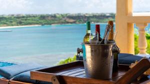 a bucket of wine bottles on a table with a view at Villa Nirvana in North Hill Village +43 photos