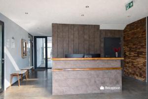 a lobby with a bar with a counter and benches at JG Hotel & Restaurant Antoniergasse in Memmingen