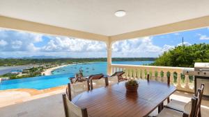 a balcony with a table and a view of the water at Villa Nirvana in North Hill Village