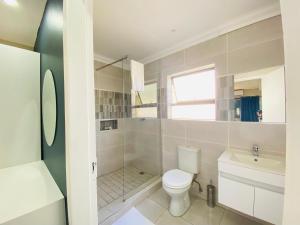 a white bathroom with a toilet and a sink at Golf View Guest House in Mahikeng +43 photos