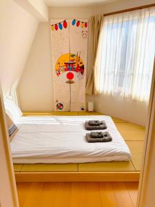 a small bedroom with a bed with white sheets at Ueno 10minutes, Tokyo University 10minutes, three BR, three toilets, Max 10 people Free parking in Tokyo