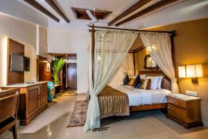 a bedroom with a bed with a canopy at Tangerine Boutique Resort in Calangute +54 photos
