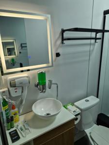 a bathroom with a sink and a toilet and a mirror at 2210 CadBox Suíte, Hidro, Churrasqueira, Cozinha Privativo in Sao Jose do Rio Preto