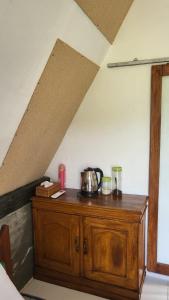a wooden cabinet with a tea kettle on top of it at Zalfa Homestay in Taliwang