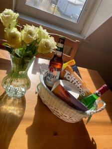 a basket of beer and champagne and flowers on a table at FEWO RENKEN in Trassenheide