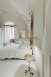 a bedroom with a white bed and a chair at Palazzo Mimì in Bitritto
