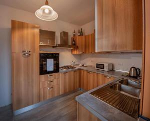 a kitchen with wooden cabinets and a sink and a microwave at Il loggiato del chianti in Cavriglia