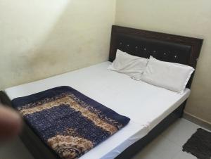 a bed with white sheets and pillows in a room at Shri Krishna Guest House in Mathura