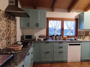a kitchen with green cabinets and a counter top at Masía Can Janàs in Lliçà d'Amunt +17 photos