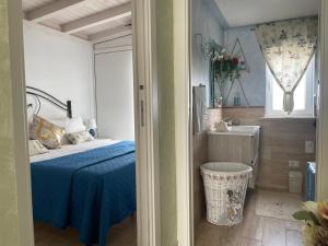 a bedroom with a blue bed and a sink at La Terrazza Solarium, in pieno centro 60m dalla stazione ferroviaria 700m dal mare in Santa Flavia