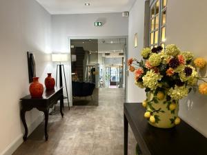 a living room with a vase of flowers on a table at Hôtel Saint Albert in Sarlat-la-Canéda