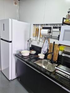 a kitchen with a sink and a white refrigerator at 2210 CadBox Suíte, Hidro, Churrasqueira, Cozinha Privativo in Sao Jose do Rio Preto +21 photos