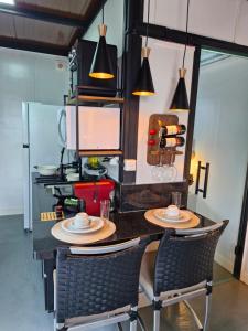 a kitchen with a table with two chairs and lights at 2210 CadBox Suíte, Hidro, Churrasqueira, Cozinha Privativo in Sao Jose do Rio Preto