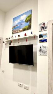 a flat screen tv hanging on a wall at Civico77AirPort in Naples
