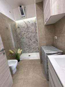 a bathroom with a shower and a toilet and a sink at Civico77AirPort in Naples +12 photos