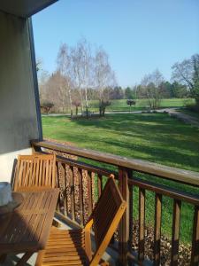 a balcony with a table and chairs and a field at Chez Louis in Levernois