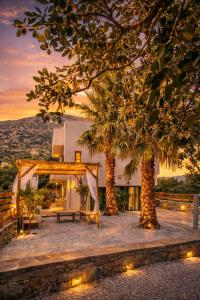 a backyard with a tent and two palm trees at Haroupia The Residence in Kalidhón