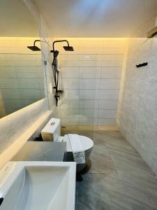 a white bathroom with a toilet and a sink at โรงแรมแซนด์บอกซ์ นครศรีธรรมราช in Nakhon Si Thammarat +14 photos