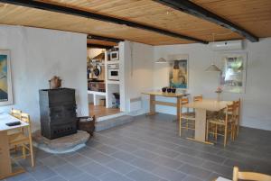 a living room with a stove and a table and chairs at Vejskrækgården in Fæbæk