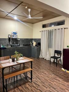 a living room with a table and a kitchen at Prime Cottage 2bhk independent cottage home in Dimāpur