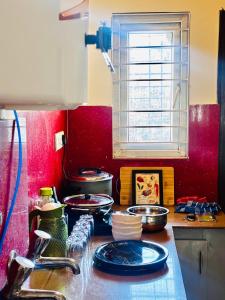 a kitchen with red walls and a counter top with dishes at Indigo Homes Kondapur in Hyderabad