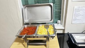 Ein Tablett mit Essen auf der Theke, dazu Gabel und Tomaten. in der Unterkunft Hotel Moraes próximo a 25 de Março, Brás e Bom Retiro - Reserve agora e só pague no check-in in São Paulo