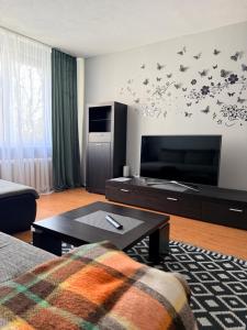 a living room with a couch and a tv at Parko apartamentai Kretinga in Kretinga