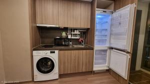 a kitchen with a washing machine and a refrigerator at Haeon stay haeundae in Ch'ŏngsap'o