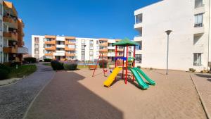 a playground with a slide in the sand next to a building at Departamento familiar in La Serena