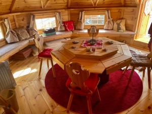 a room with a wooden table and chairs in a cabin at KOTA bien être jaccuzzi , sauna , piscine chauffée , soins bien être in Voissant
