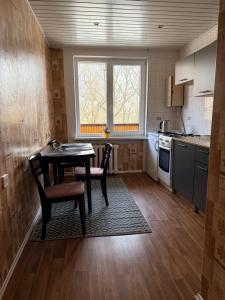 a kitchen with a table and two chairs and a table at Parko apartamentai Kretinga in Kretinga