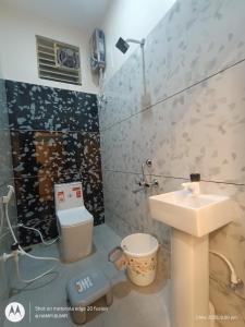 a bathroom with a sink and a toilet at Smarami homestay in Hospet