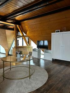 a living room with a glass table and a tv at Haus Anna in Oberdachstetten