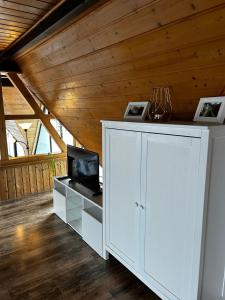 a white cabinet in a room with a wooden ceiling at Haus Anna in Oberdachstetten