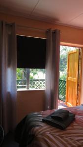 a bedroom with a bed and a window with a blind at Birdsong Cottage in Howick +39 photos
