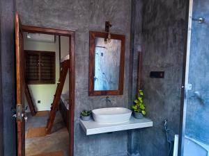 a bathroom with a sink and a mirror at Trinco Beach Bunks in Trincomalee