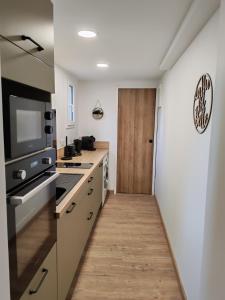 a kitchen with white counters and a wooden door at Roger's appartement in Larrivière