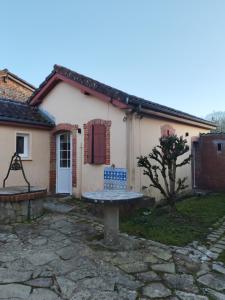 a small white house with a bench in front of it at Roger's appartement in Larrivière