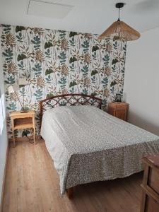 a bedroom with a bed with a patterned wall at Roger's appartement in Larrivière