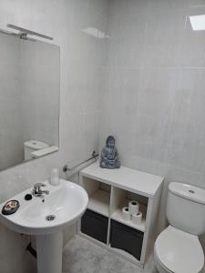 a white bathroom with a sink and a toilet at Casa de Fernando in Treacastela +12 photos