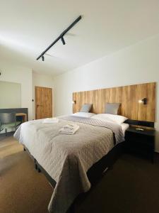 a bedroom with a large bed with a wooden headboard at Apartmány Stagnum Liptovský Ján in Liptovský Ján