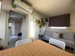 a living room with a couch and a table at Top Floor Apt with Balcony - Acropolis View & Sunset - Koukaki in Athens