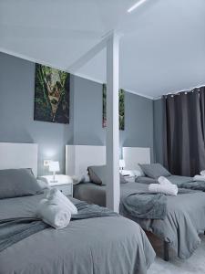 a room with three beds with towels on them at Casa de Fernando in Treacastela