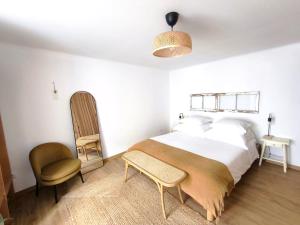 a bedroom with a large bed and a chair at O Refúgio do Pim in Horta