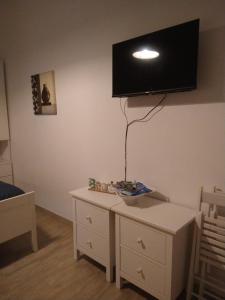 a room with a dresser with a tv on the wall at Casa nonna Gina in Genoa