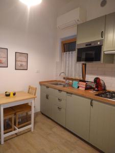 a kitchen with a sink and a counter with a table at Casa nonna Gina in Genoa