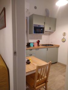 a small kitchen with a wooden table and a wooden chair at Casa nonna Gina in Genoa +1 photo