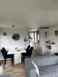 a living room with a table and a couch at Chalet Inn Ameland inclusief Fietsen, Zee en Strand op loopafstand! in Buren